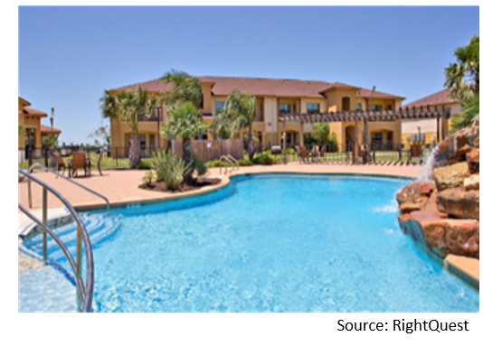 Exterior of a mexican-style apartment complex with resort-style pool on sunny day