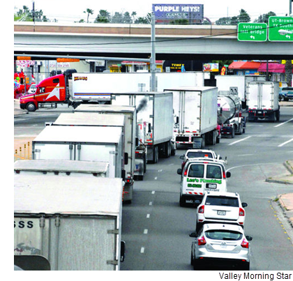 Trucks lined up along International Boulevard make their way to the Veteran’s Memorial Bridge.