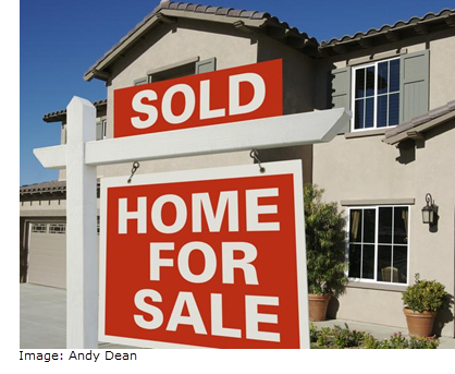 front view of a house with a for sale sign on the front line