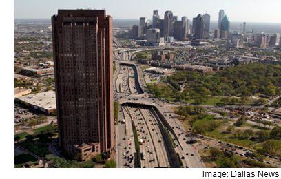 A view of the Tower at Cityplace with a view of downtown Dallas in the background.