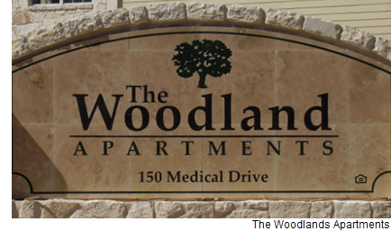 The Woodlands Apartments community street sign.
