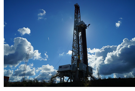 An image of a oil well with a dramatic blue sky background.