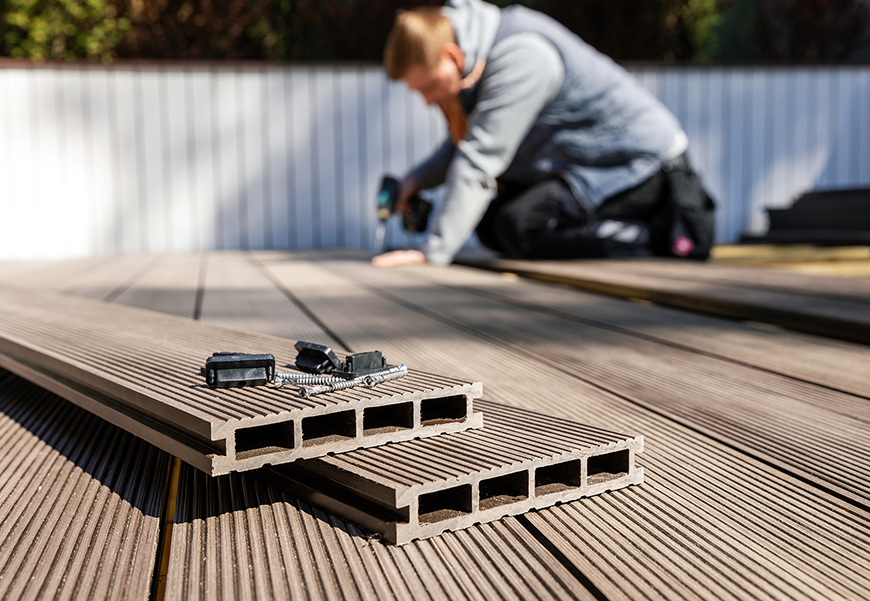 wpc terrace construction – worker installing wood plastic composite decking boards